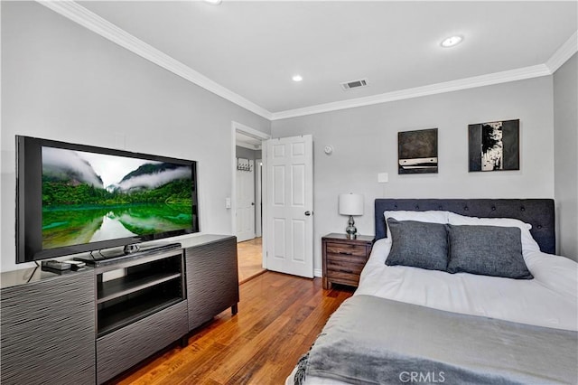 bedroom with ornamental molding, visible vents, recessed lighting, and wood finished floors