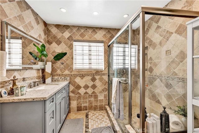 full bath featuring tile walls, vanity, recessed lighting, and a shower stall