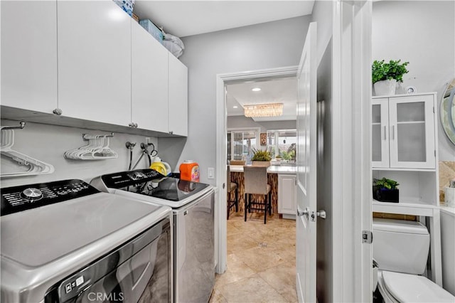 laundry room with cabinet space, washing machine and dryer, and recessed lighting