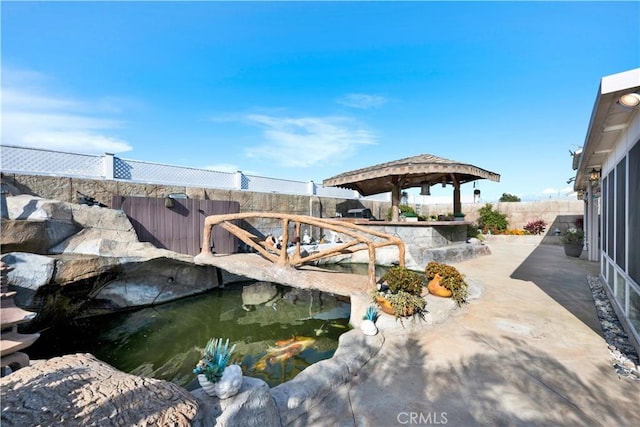 exterior space with a fenced backyard and a small pond