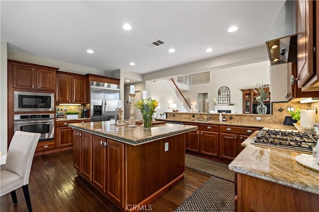38925 Cherry Point Ln, Murrieta, CA 92563 - kitchen featuring built in appliances, visible vents, dark wood-type flooring, and light stone counters