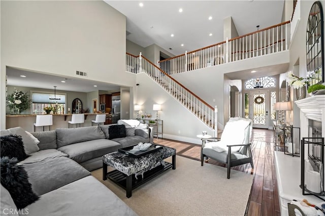 38925 Cherry Point Ln, Murrieta, CA 92563 - living area featuring visible vents, recessed lighting, a towering ceiling, wood finished floors, and stairs