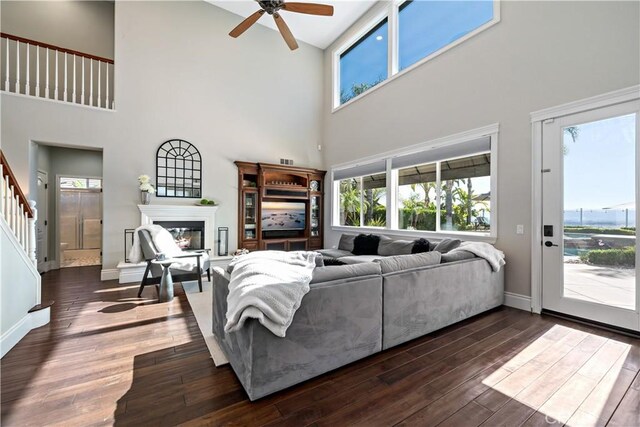 38925 Cherry Point Ln, Murrieta, CA 92563 - living room with a high ceiling, dark wood-style flooring, a wealth of natural light, and a glass covered fireplace
