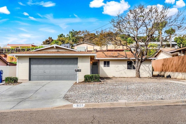 ranch-style house with driveway, fence, and an attached garage