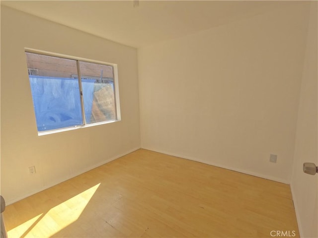 unfurnished room featuring baseboards and wood finished floors