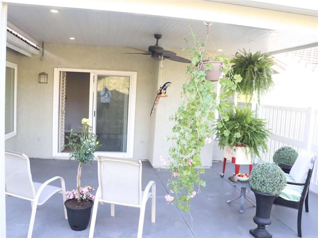 view of patio featuring a wall unit AC and ceiling fan
