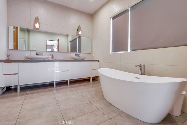 737 N Cherokee Ave, Los Angeles, CA 90038 - bathroom featuring a soaking tub, double vanity, a sink, and tile patterned flooring