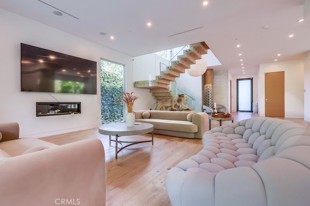 737 N Cherokee Ave, Los Angeles, CA 90038 - living room with stairs, light wood-style flooring, a glass covered fireplace, and recessed lighting