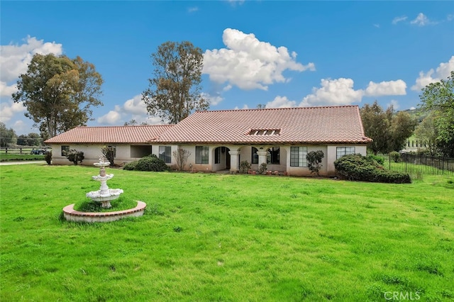 view of front of home featuring a tile roof, a front lawn, and fence