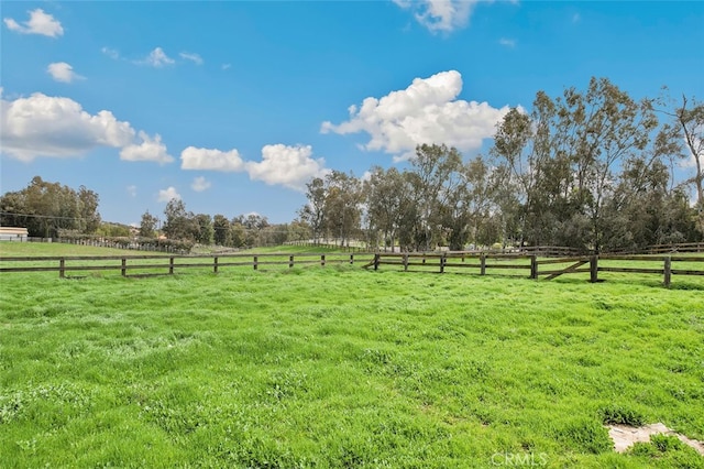 view of yard featuring fence and a rural view
