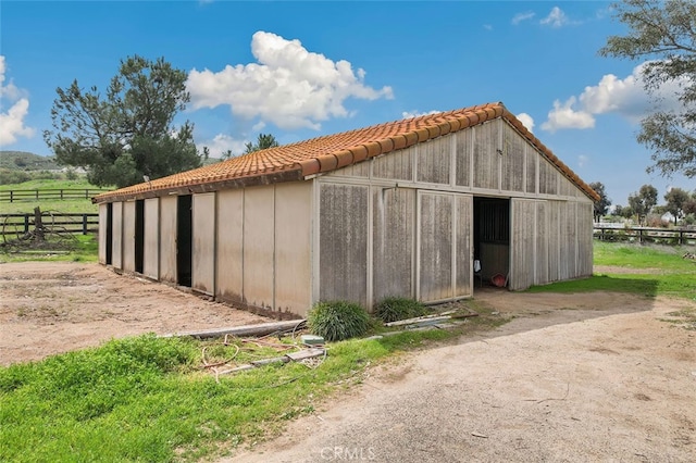 view of outbuilding with an outdoor structure and fence