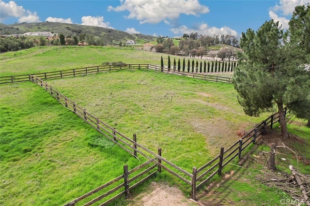 view of yard with fence and a rural view