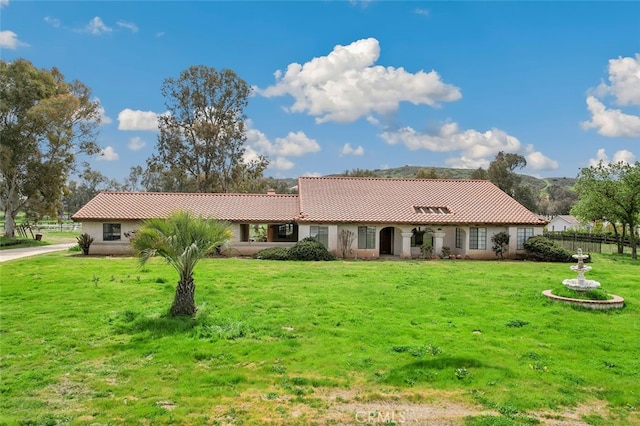 ranch-style house with fence, stucco siding, a tile roof, and a front yard
