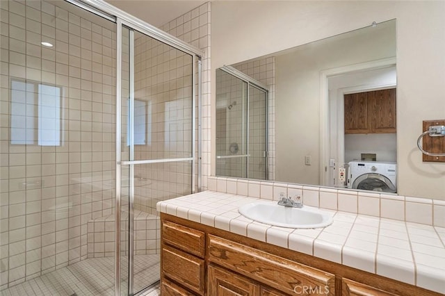 full bathroom with vanity, washer / dryer, and a shower stall
