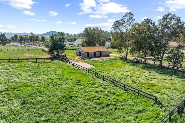 view of yard with an outdoor structure, a rural view, an exterior structure, and a mountain view