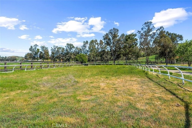 view of yard featuring fence and a rural view
