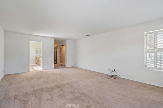 spare room with visible vents and light carpet