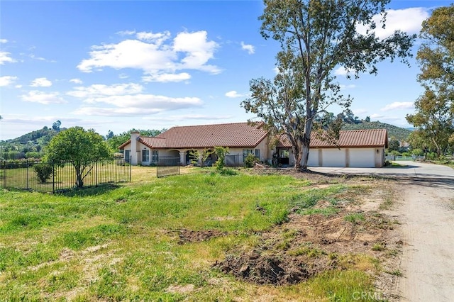 ranch-style house with dirt driveway, a tiled roof, stucco siding, fence, and a garage