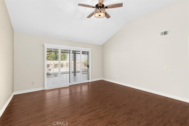 spare room with ceiling fan, baseboards, vaulted ceiling, and dark wood finished floors
