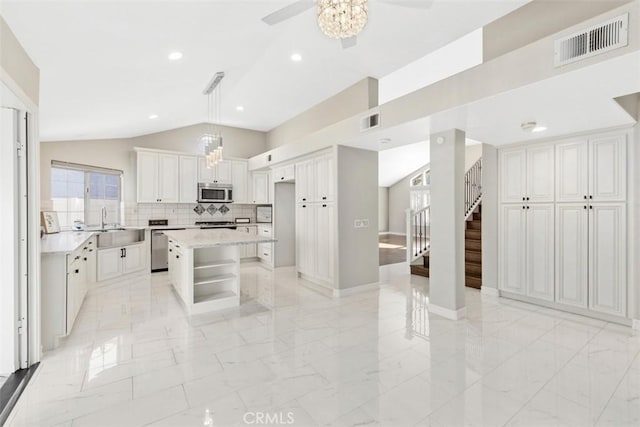 kitchen with a ceiling fan, visible vents, appliances with stainless steel finishes, marble finish floor, and lofted ceiling