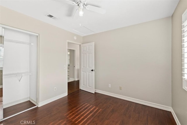 unfurnished bedroom with baseboards, wood finished floors, a closet, and visible vents