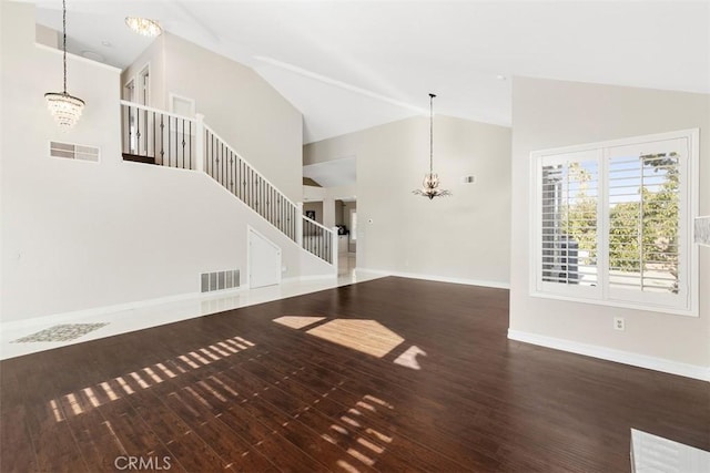 unfurnished living room featuring visible vents, wood finished floors, stairs, baseboards, and a notable chandelier