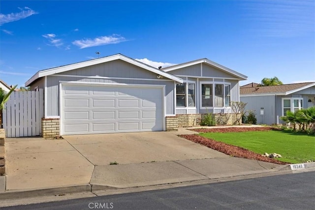 view of front facade featuring concrete driveway, a garage, and a front lawn