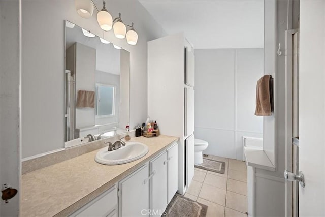bathroom featuring tile patterned flooring, toilet, and vanity