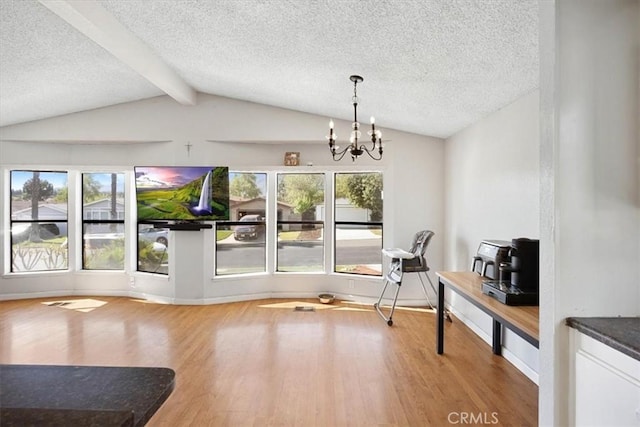 dining room featuring baseboards, an inviting chandelier, a textured ceiling, vaulted ceiling with beams, and wood finished floors