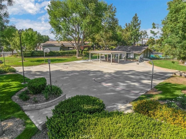 view of home's community with a pergola, community basketball court, and a lawn
