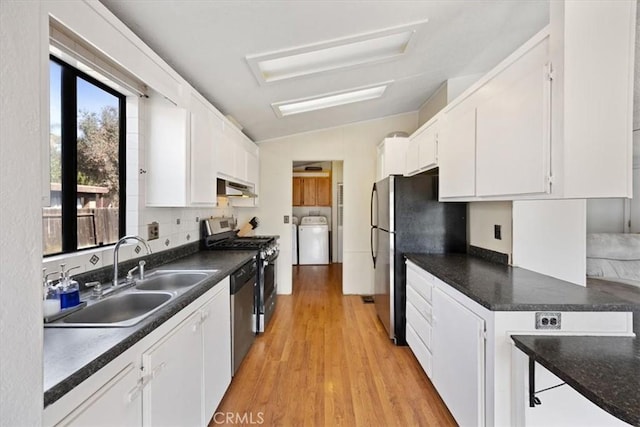 kitchen with washer / clothes dryer, white cabinets, a sink, under cabinet range hood, and stainless steel appliances