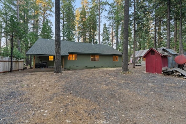 7528 Humboldt Rd, Butte Meadows, CA 95942 - rear view of house with crawl space, a storage unit, fence, an outbuilding, and a shingled roof
