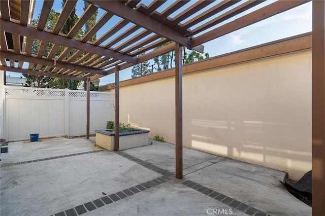 view of patio with a pergola and fence