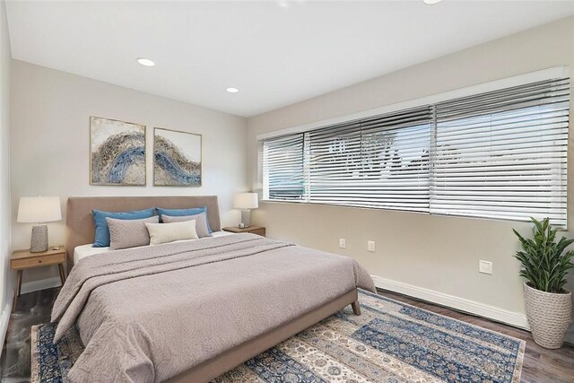bedroom with wood finished floors, baseboards, and recessed lighting
