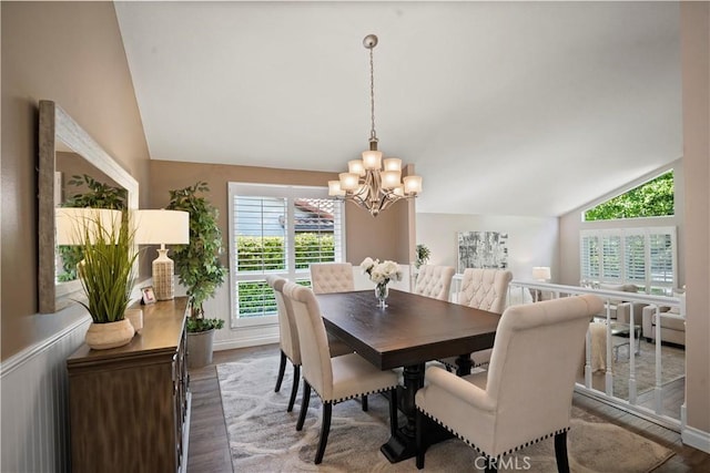 dining space featuring a notable chandelier, wood finished floors, and lofted ceiling