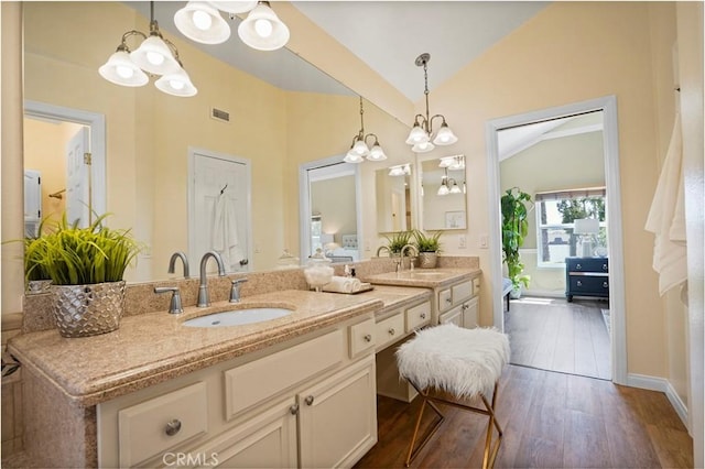 full bath featuring a sink, double vanity, wood finished floors, and vaulted ceiling