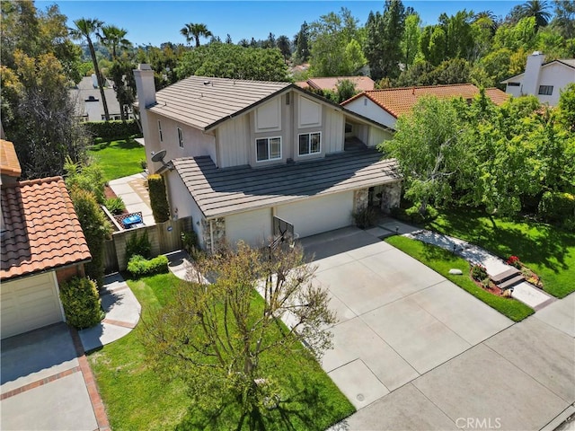 view of front of house featuring a tiled roof, concrete driveway, a garage, and stucco siding