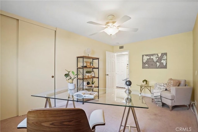 carpeted office space featuring visible vents, baseboards, and ceiling fan