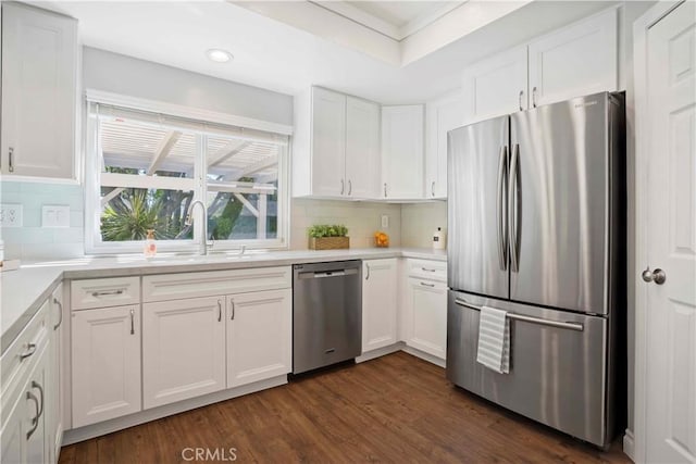 kitchen featuring tasteful backsplash, a sink, dark wood-style floors, white cabinetry, and stainless steel appliances
