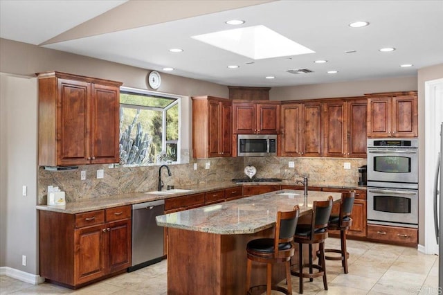 16270 Pauma Valley Dr, Pauma Valley, CA 92061 - kitchen with stainless steel appliances, a skylight, light stone counters, decorative backsplash, and recessed lighting