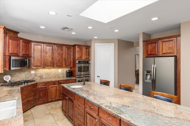 16270 Pauma Valley Dr, Pauma Valley, CA 92061 - kitchen featuring appliances with stainless steel finishes, a skylight, backsplash, recessed lighting, and light stone counters
