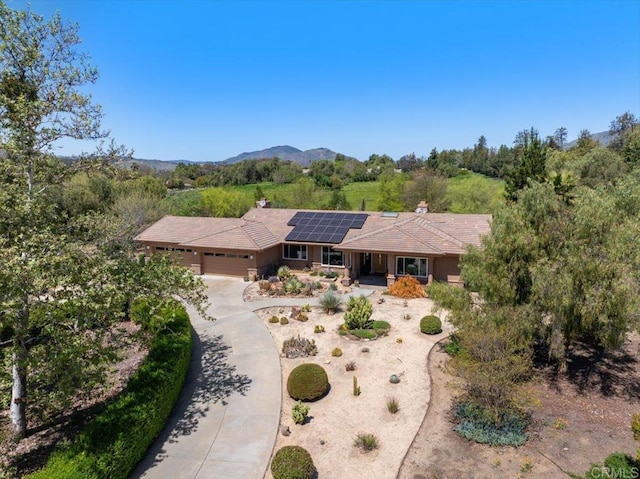 16270 Pauma Valley Dr, Pauma Valley, CA 92061 - single story home with an attached garage, driveway, roof mounted solar panels, covered porch, and a chimney
