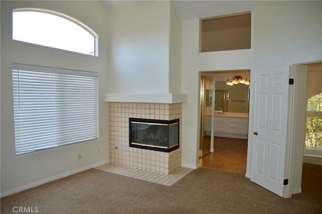 24391 Rue De Gauguin, Laguna Niguel, CA 92677 - unfurnished living room featuring carpet flooring, a fireplace, and a towering ceiling