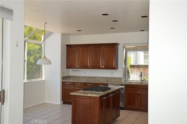 24391 Rue De Gauguin, Laguna Niguel, CA 92677 - kitchen with light tile patterned flooring, plenty of natural light, a kitchen island, light stone counters, and a textured ceiling