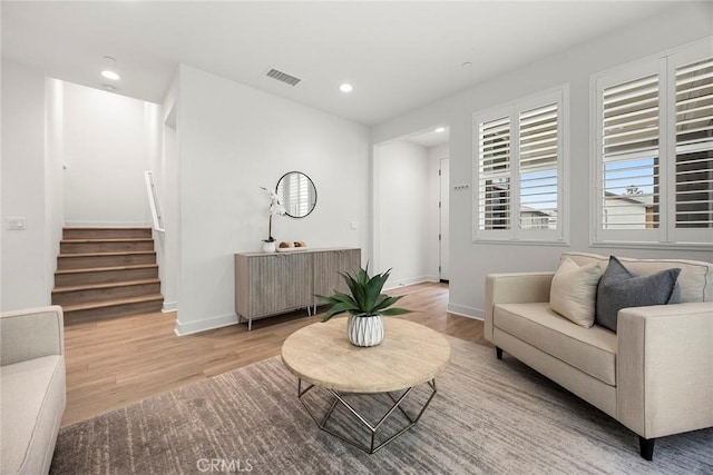 living area with visible vents, recessed lighting, wood finished floors, and stairway