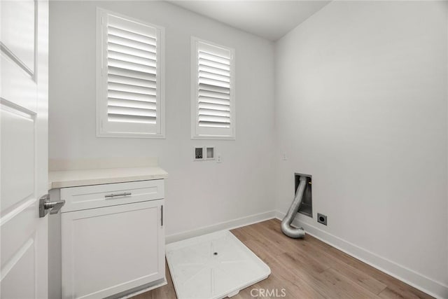 laundry area featuring washer hookup, electric dryer hookup, cabinet space, baseboards, and light wood-style floors