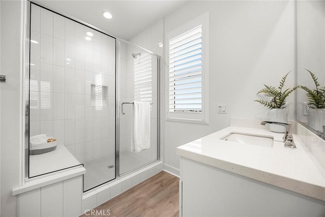 bathroom with vanity, wood finished floors, baseboards, recessed lighting, and a stall shower