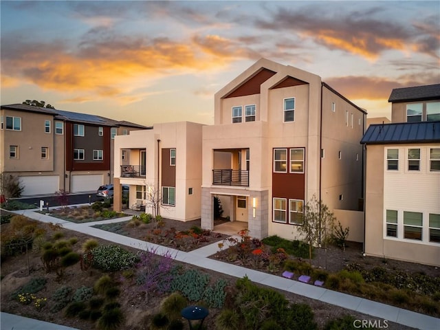 view of front of house with stucco siding and a balcony