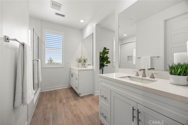 bathroom featuring visible vents, a sink, baseboards, and a stall shower