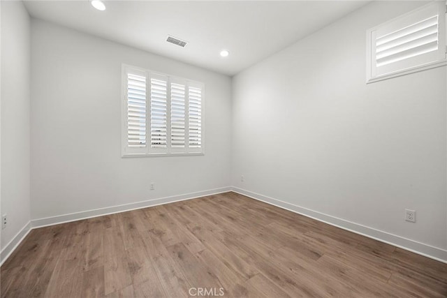unfurnished room featuring recessed lighting, baseboards, and wood finished floors